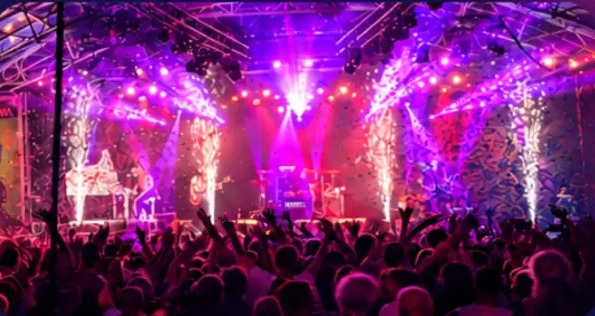 Uitgelicht evenement: podium met paarse lichtshow en juichend publiek